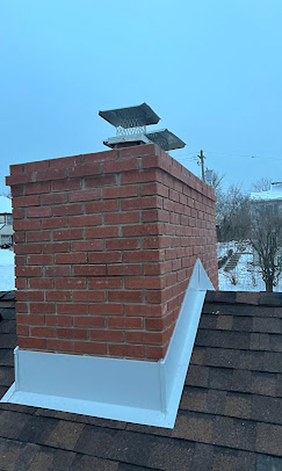 Close-up of new flashing detail around rebuilt brick chimney